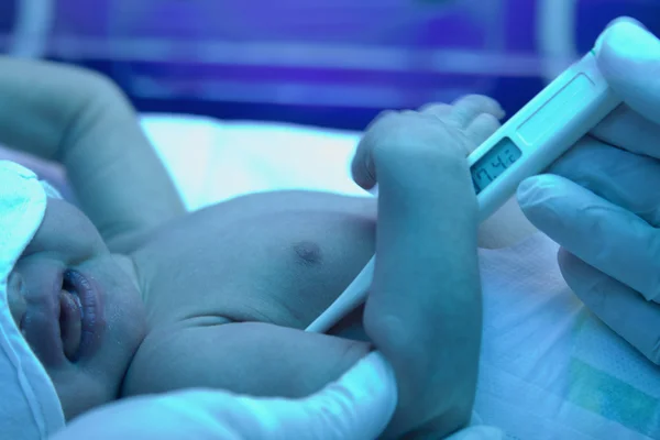 Measuring temperature to a sick new born baby — Stock Photo, Image