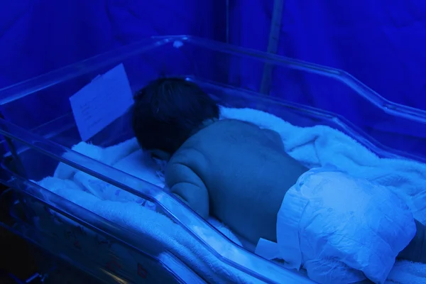 Newborn baby under ultraviolet lamp in the incubator — Stock Photo, Image