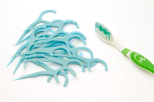 Soins dentaires, pile de fil dentaire cueillette et brosse à dents — Photo