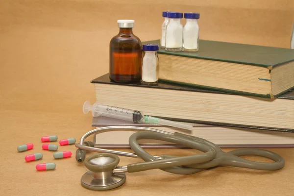 Stéthoscope et médicaments sur le livre médical — Photo