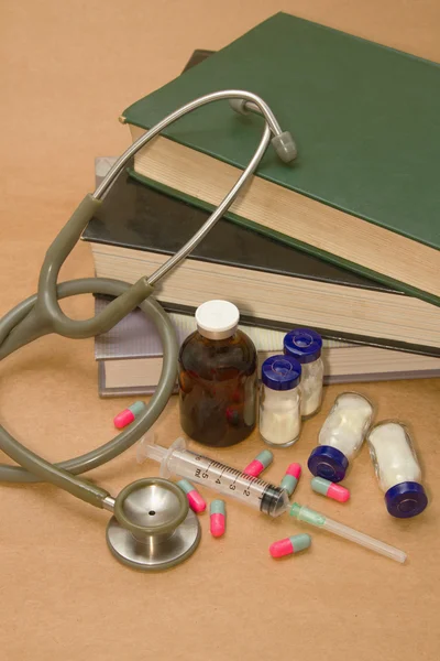 Stetoscopio e farmaci sul libro medico — Foto Stock