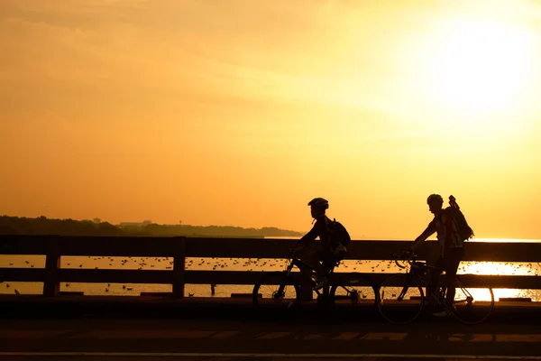 Silhouette du motard sur le pont au coucher du soleil — Photo