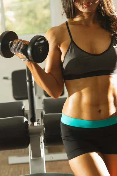 Torso of a young fit woman lifting dumbbells — Stock Photo, Image
