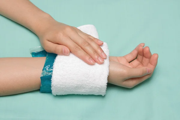 Eine Frau mit Kältepackung auf geschwollenem, schmerzhaftem Handgelenk nach einem Accid — Stockfoto