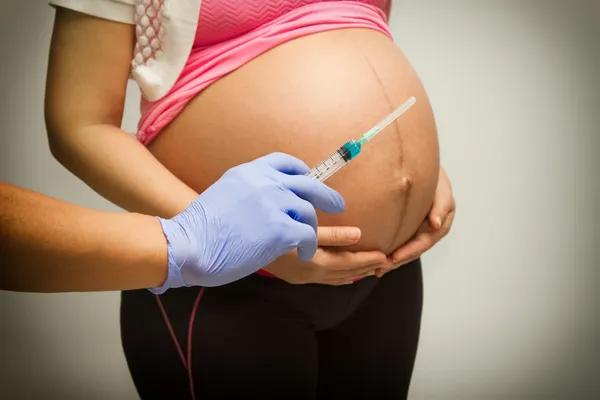 Donna incinta con siringa, Vaccinare una donna incinta — Foto Stock