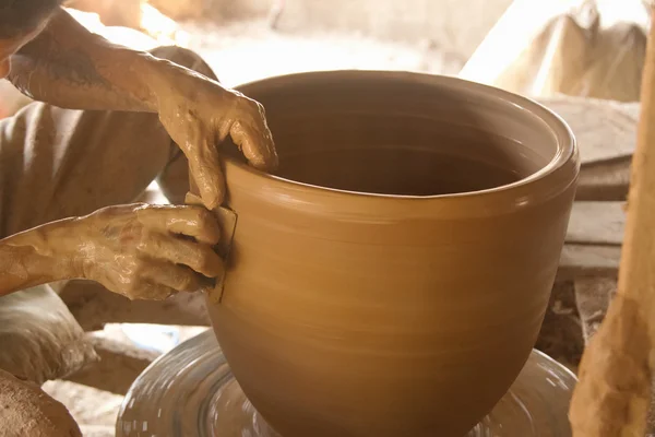 Les mains de Potter travaillant sur un pot à sa roue de poterie — Photo