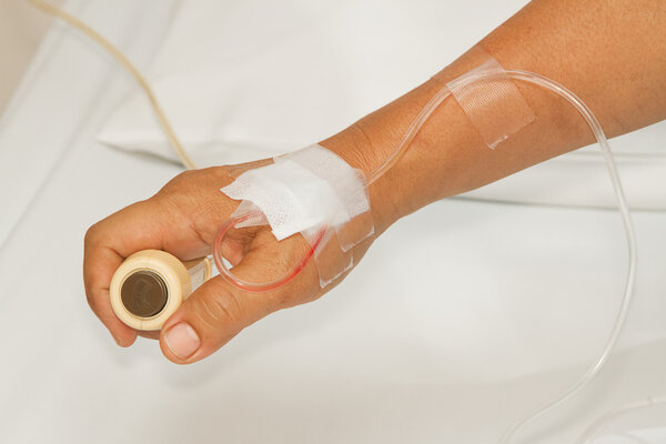 Hand pressing emergency nurse call button