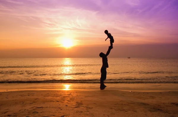 Pai e filho na praia do pôr do sol, silhueta — Fotografia de Stock