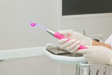 diş hekimi diş kliniğinde ışıklı diş kür uv ışık tutan
