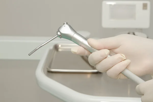 Mão do dentista segurando ferramenta dentária na clínica odontológica — Fotografia de Stock