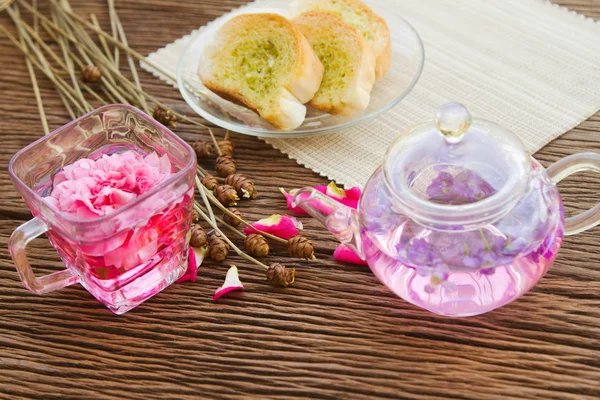 Розовый чай и домашний чесночный хлеб на столе в саду, после — стоковое фото