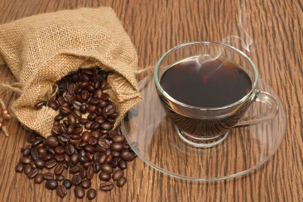 Xícara de café e grãos de café no fundo de madeira velha — Fotografia de Stock