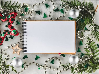 Noel ve Yeni Yıl dekorasyonları masada yatıyor.