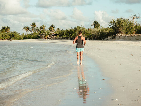 Young man running along the coast of the Atlantic Ocean