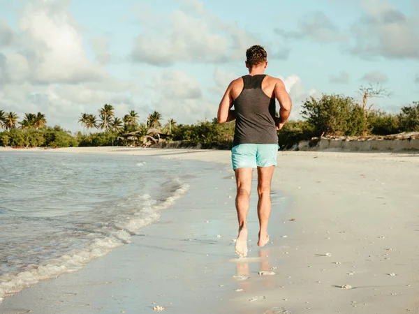 Young man running along the coast of the Atlantic Ocean — Zdjęcie stockowe