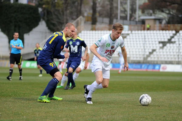 Kaposvar, Hongarije - 16 maart: kink tarmo (wit 9) in actie op een Hongaarse kampioenschap voetbalspel - kaposvar (wit) vs puskas akademia (blauw) op 16 maart 2014 in kaposvar, Hongarije. — Stockfoto