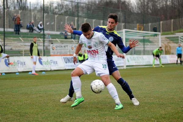 KAPOSVAR, HUNGRÍA - 16 DE MARZO: Firtulescu Dragos Petrut (blanco 10) en acción en un partido de fútbol del Campeonato de Hungría Kaposvar (blanco) vs Puskas Akademia (azul) el 16 de marzo de 2014 en Kaposvar, Hungría . — Foto de Stock