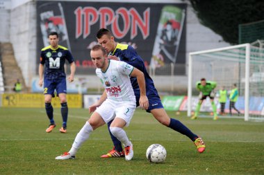 Kaposvar, Macaristan - 16 Mart: florean andrei-alexandru (beyaz) eylem Macaristan Ligi futbol maçı - kaposvar (beyaz) vs puskas akademia (mavi) üzerinde 16 Mart 2014 yılında kaposvar, Macaristan.