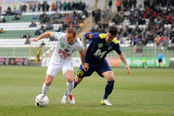 Kaposvar, Macaristan - 16 Mart: florean andrei-alexandru (beyaz) eylem Macaristan Ligi futbol maçı - kaposvar (beyaz) vs puskas akademia (mavi) üzerinde 16 Mart 2014 yılında kaposvar, Macaristan.