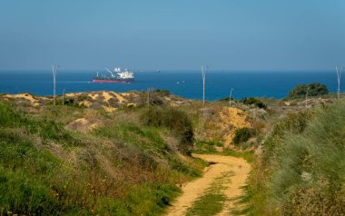 Akdeniz manzarası ve yol kenarında bir kargo gemisi var. İsrail Ashkelon Şubat 2021
