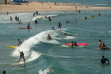 Sörf ve uçurtma sörfü. Farklı yaşlardaki insanlar Akdeniz 'in güzel arka planında ata biner ve her türlü numarayı yaparlar. Spor, sağlık, eğlence kavramı. İsrail Ashkelon Temmuz 2021