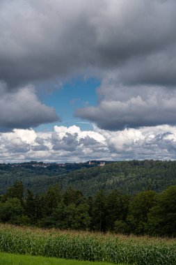Ormanın ortasındaki bir tepede küçük bir köy ve mısır tarlası.
