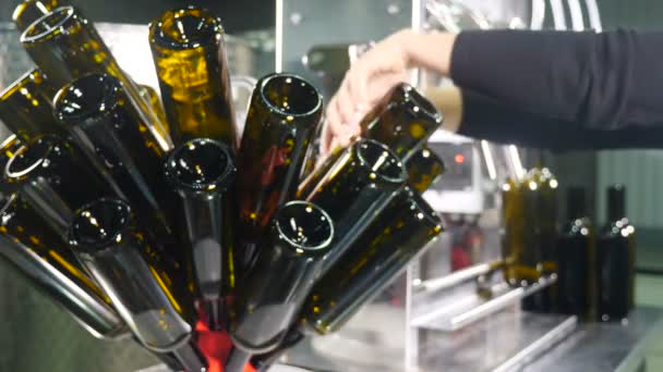 Γεμίζοντας καφέ γυάλινα μπουκάλια με κρασί από το μηχάνημα στο οινοποιείο. Τα άδεια μπουκάλια γεμίζουν με υγρό. Παραγωγή κρασιού. Εργοστάσιο εμφιάλωσης κρασιού. Εργαστήρι με τους εργαζόμενους όπου το κρασί εμφιαλώνεται. 4 k βίντεο — Αρχείο Βίντεο