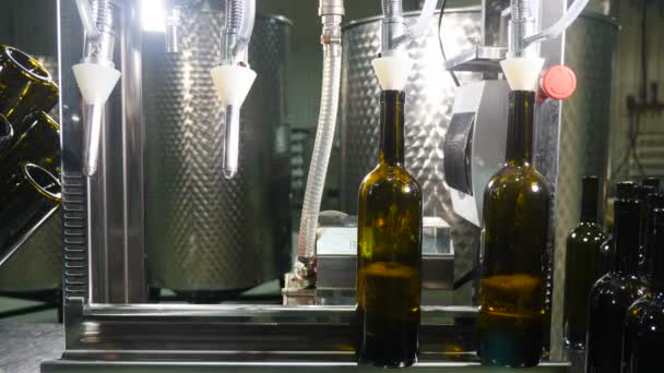 Llenado de botellas de vidrio marrón con vino por máquina en bodega. Las botellas vacías están llenas de líquido. Producción de vino. Fábrica de embotellado de vino. Taller con trabajadores donde se embotella vino. 4 k vídeo — Vídeo de stock