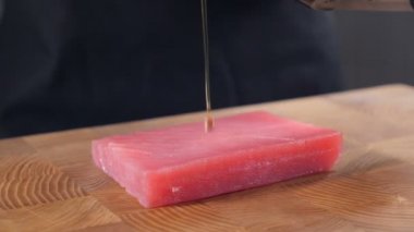 Ton balığının üzerine zeytinyağı dök. Ağır çekim. Şef sağlıklı gurme yemeği pişiriyor. Deniz ürünleri hazırlığı. Balık bifteği pişiriyorum. Şef balık pişirmeye başladı. Çiğ balık. Tam Hd