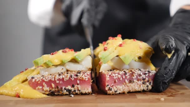 Chef cutting ready tuna steak on wooden board. Healthy dish with scallops, avocado and mango sauce. Slow motion. Red edge of Seared Tuna Dish. Preparing seafood in restaurant kitchen. Full hd — Stock Video