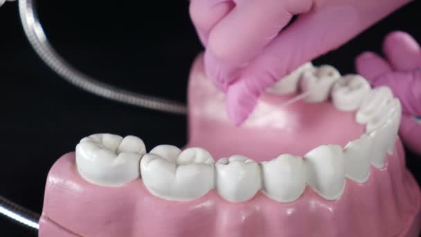 Toont of leert op model hoe tanden verzorgen met tandflossen. Gebruik van tandzijde. Flossen Tanden Met Floss op zwarte achtergrond. Tandverzorging hygiëne, Teeth Cleaning en caries preventie. 4 km — Stockvideo