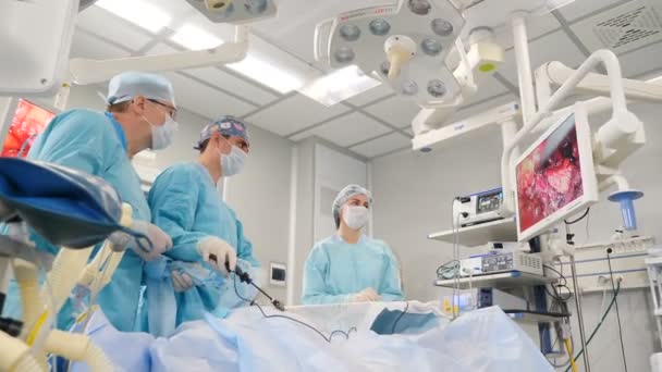Operační sál, tým chirurgů provádějících laparoskopický zákrok. Moderní medicína, lékařské vybavení v nemocnici. Laparoskopické nástroje. Doktoři používají endo-nástroje a videokamery. 4 k — Stock video