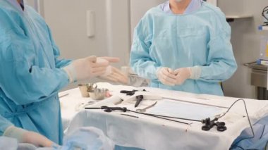 Doktor cerrah, tıbbi müdahaleden önce ellerini eldivenle dezenfekte eder ve yıkar. Dezenfeksiyon. Hastane ya da klinikte cerrahi ve hijyen kuralları. Tıp çalışanı lastik eldivenleri siliyor.