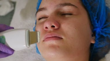 Beaury Kliniği 'nde ultrasonik yüz temizleme. Kadın ultrasonda yüz soyma ve temizleme yaptırıyor. Kozmetoloji ve yüz bakımı. Yüz tedavisi, profesyonel ekipman kullanan bir güzellik uzmanı.