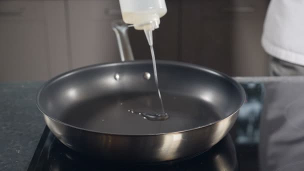Olie in de koekenpan gieten, slow motion. Er komt rook uit de pan. Chef begint te koken. Voedselvideo concept. Koken is makkelijk. Vol hd — Stockvideo