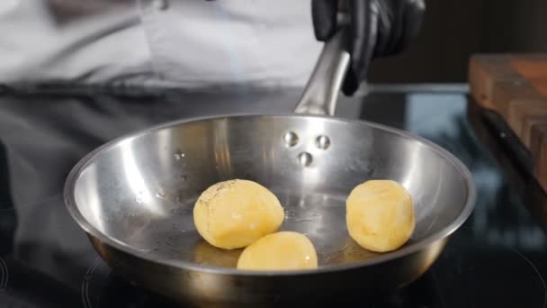 Roasting potato in frying pan with gas burner torch. Slow motion. Cooking food with flame. Fine cuisine. Restaurant chef performing master level in cooking. Close up. Shot in full hd. — Stock videók