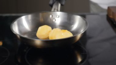 Chef tossing young potato while frying. Slow motion. Potatoes being cooked in Pan. Frying Fresh Baby Potatoes. cook throws potato on frying pan. Cooking food in restaurant kitchen. Full hd