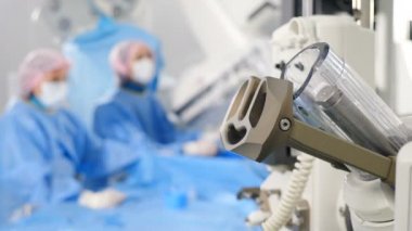 Vascular surgery in modern clinic. Blurred footage. Doctors in surgical gowns and gloves carrying out operation on veins using latest technology. Heart disease. Cardio-vascular examination. operation