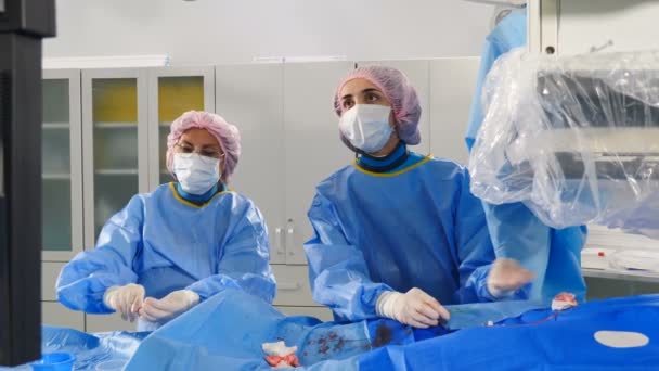 Vascular surgery in modern clinic. Professional doctors in surgical gowns and gloves carrying out operation on veins using latest technology. Heart disease. Cardio-vascular examination. operation — Video Stock