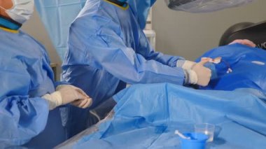 Vascular surgery in modern clinic. wound on arm. Surgeons using surgical tools during operation varicose veins, Radiologist performs endovascular operation with angiography machine. Cardio-vascular