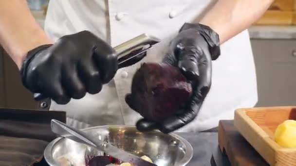 Chef peeling boiled beet, close-up. Cleaning beetroot with knife for cooking. Cooking food in restaurant. Vegetable salad dish. Traditional recipe. beets soup. 4 k video — Wideo stockowe