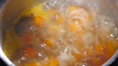 Pieces of pumpkin are stewed in saucepan with water after roasting. Making pumpkin puree soup. Boiling zucchini. Water boils, steam comes out. Ingredients for soup in boiling water in saucepan. top
