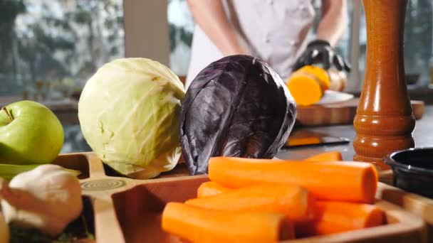 Professional chef in black gloves slicing juicy pumpkin. Cooking healthy vegetable dish. seasonal food, Cutting orange pumpkin with knife. Shot through vegetable. Raw pumpkin pieces. Sliced vegetables — Stockvideo