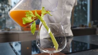 Pouring celery juice. Freshly squeezed celery juice being poured into blender cup. Preparation of diet and cleansing drinks. Healthy food and beverage. Making vegetable smoothie. Vertical footage. 4 k