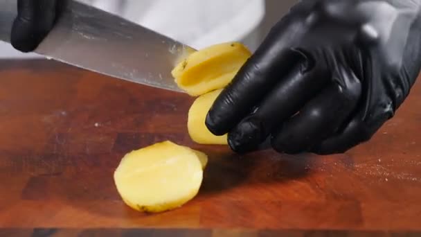 셰프가 검은 장갑을 끼면 Raw Potatoes 가 매우 빠르게 나옵니다. 위에서 본 모습. 부엌에 있는 사람은 감자를 요리하고 음식을 미리 준비 한다. 천연 재료들이 있는 식당에서 요리를 한다. 건강 한 채소. 4k 비디오 — 비디오