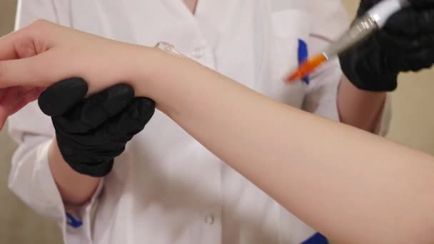 Beautician applies transparent gel on female arm before hair removal. Cosmetology in beauty salon. Removing unwanted body hair. Beauty procedure. Laser epilation in beauty spa clinic. photoepilation — Video Stock