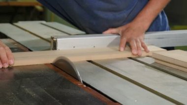 Carpenter at work cuts piece of board with circular electric saw and strokes wood with hand, Flying sawdust of working circular. Process of making wood chipboard furniture. Electric tools. 4 k video
