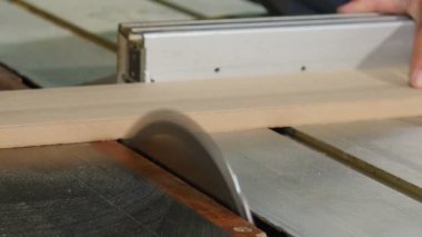 Carpenter at work cuts piece of board with circular electric saw and strokes wood with hand, Flying sawdust of working circular. Process of making wood chipboard furniture. Electric tools. 4 k video