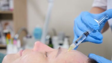 Kozmetik tedavi. Kozmetik uzmanı, kısa iğneli orta yaşlı bir kadın için güzellik aleti yapıyor. Yüz gerdirme prosedürü. Biorevitalizasyon ve mezoterapi. aktif bileşenler için kadın yüzüne