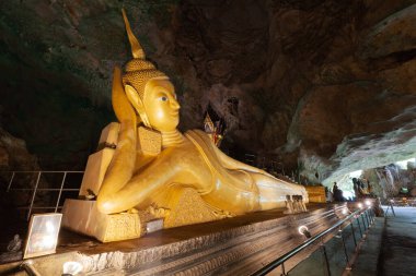 Tayland, Phang Nga 'daki Wat Tham Suwankhuha Tapınağı' nda uzanan Buda 'nın altın heykeli..